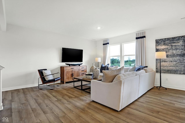 living room featuring recessed lighting, wood finished floors, visible vents, and baseboards