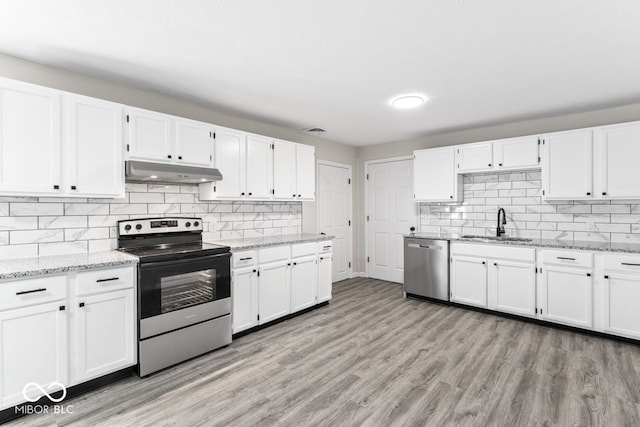 kitchen with under cabinet range hood, stainless steel appliances, a sink, white cabinets, and light wood finished floors