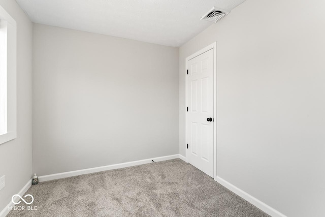 carpeted empty room with baseboards and visible vents