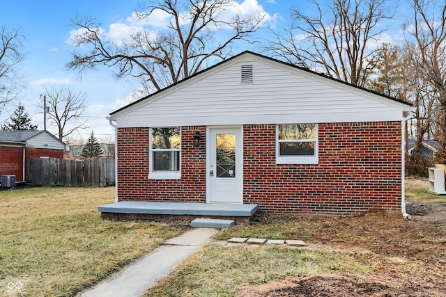 view of front of property featuring central AC, brick siding, a front lawn, and fence