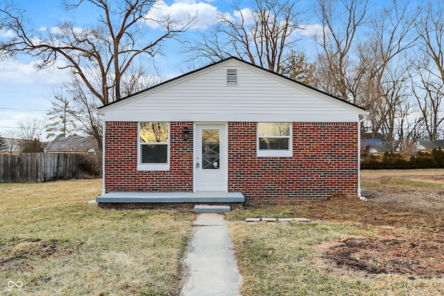 bungalow with brick siding, a front lawn, and fence