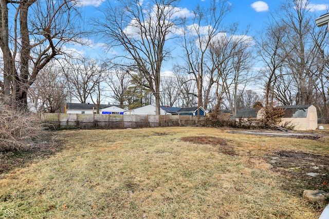 view of yard with a storage shed, an outdoor structure, and fence