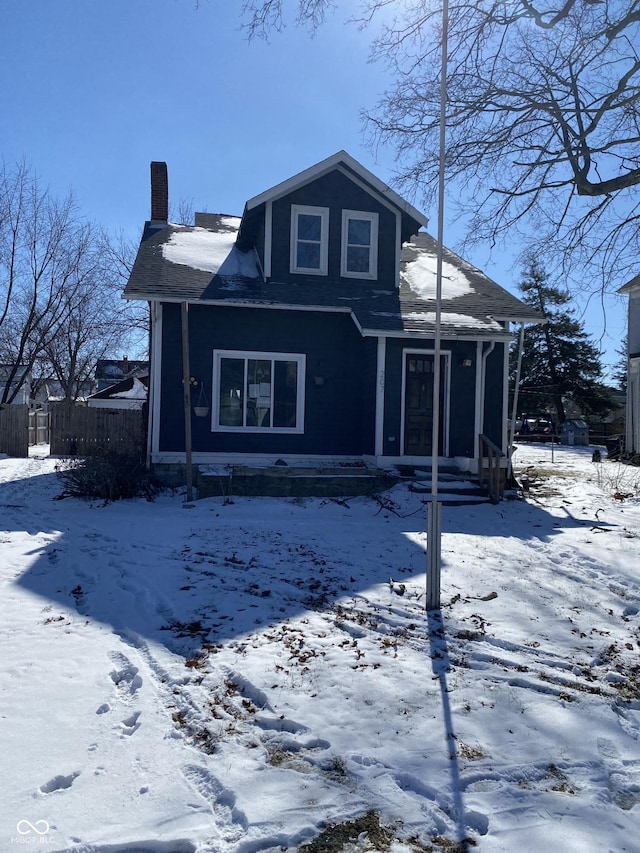 view of front of home with a chimney and fence