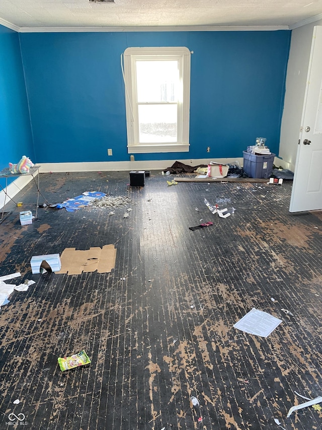 empty room with crown molding and a textured ceiling