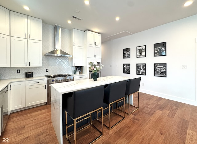 1818 N Cornell Ave, Indianapolis, IN 46202 - kitchen featuring wall chimney exhaust hood, stainless steel range, a breakfast bar, wood finished floors, and recessed lighting