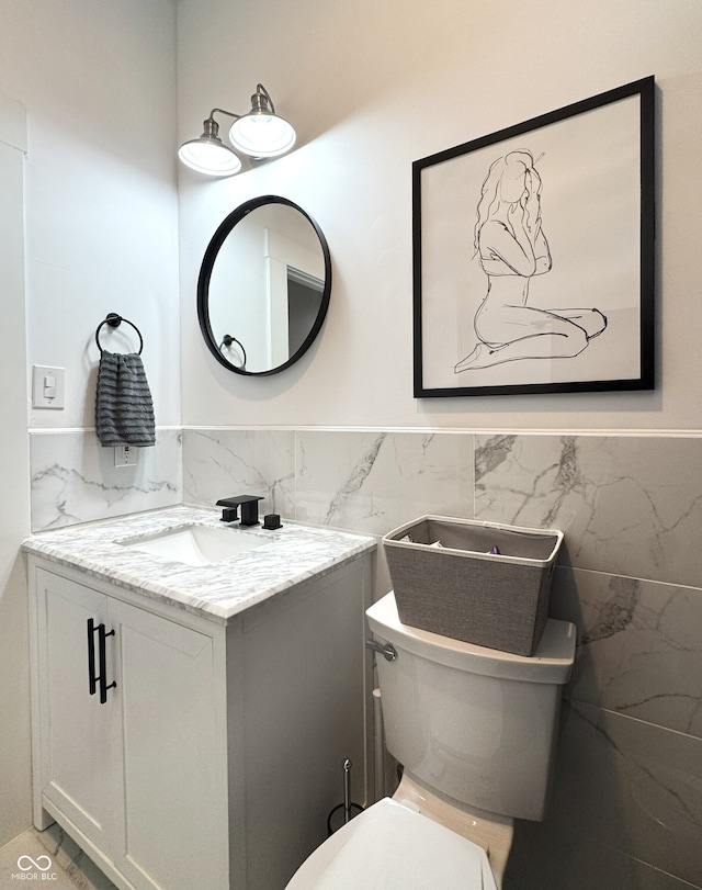 1818 N Cornell Ave, Indianapolis, IN 46202 - half bathroom featuring tile walls, vanity, wainscoting, and toilet