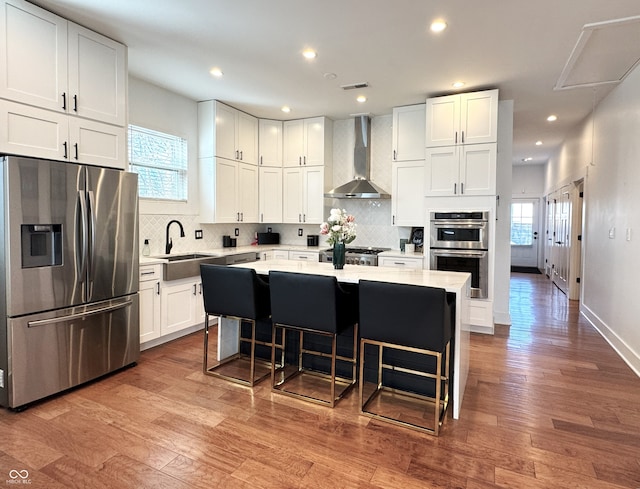 1818 N Cornell Ave, Indianapolis, IN 46202 - kitchen with stainless steel appliances, wall chimney exhaust hood, a sink, white cabinetry, and decorative backsplash