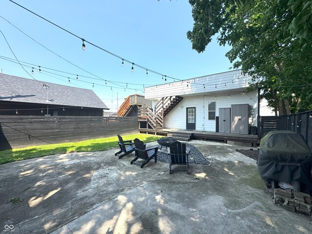 1818 N Cornell Ave, Indianapolis, IN 46202 - fenced backyard featuring an outdoor fire pit, a deck, a grill, stairs, and a patio