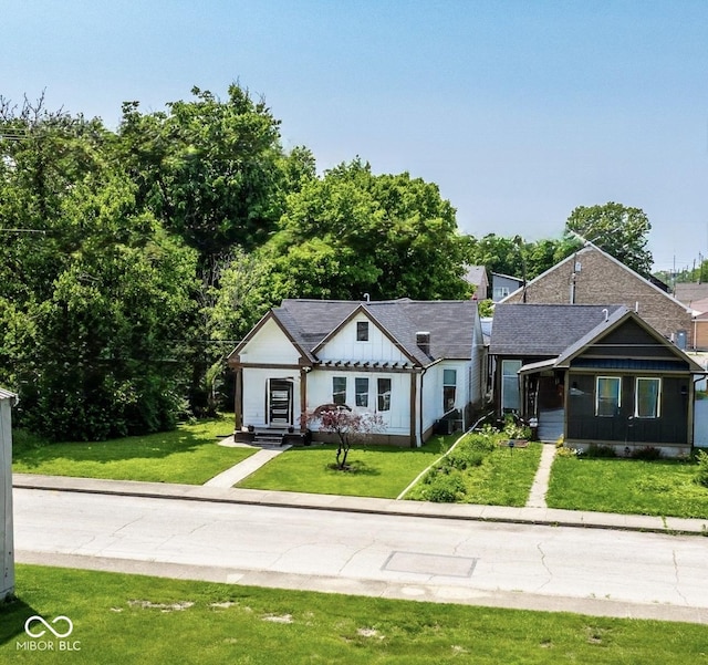1818 N Cornell Ave, Indianapolis, IN 46202 - view of front facade with board and batten siding, a front lawn, and driveway