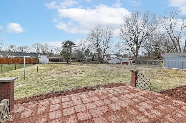 view of yard featuring a shed, an outdoor structure, a fenced backyard, and a patio