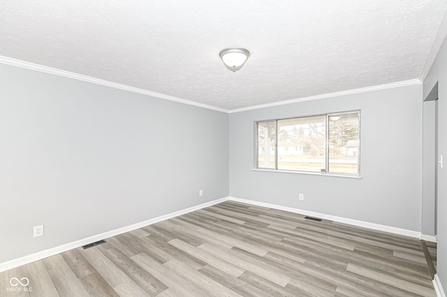 unfurnished room featuring crown molding, visible vents, a textured ceiling, wood finished floors, and baseboards