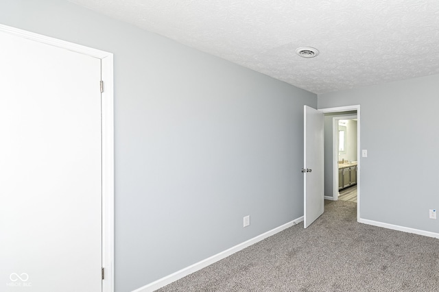 empty room with light carpet, baseboards, visible vents, and a textured ceiling