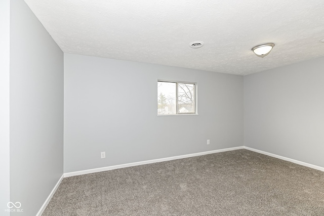 carpeted spare room featuring visible vents, baseboards, and a textured ceiling