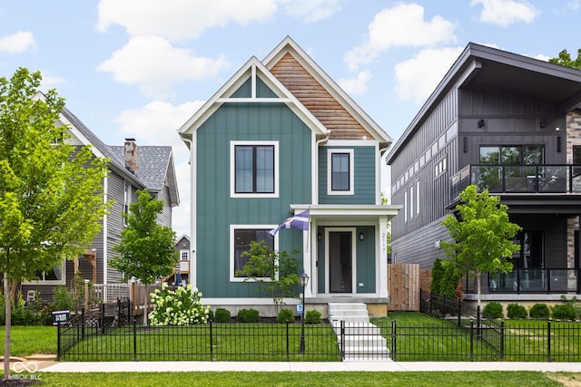 view of front of property with a fenced front yard, a front lawn, and board and batten siding