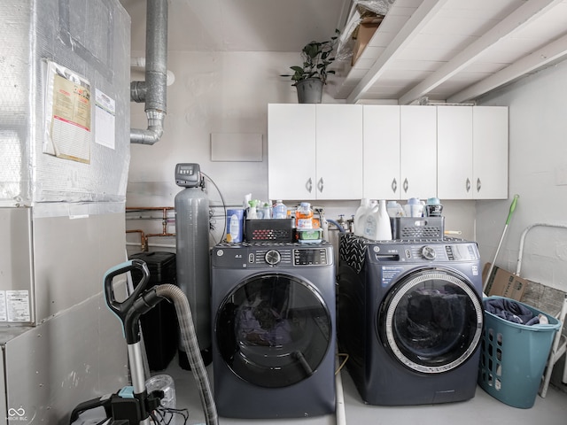 laundry area featuring cabinet space, washer and clothes dryer, and heating unit