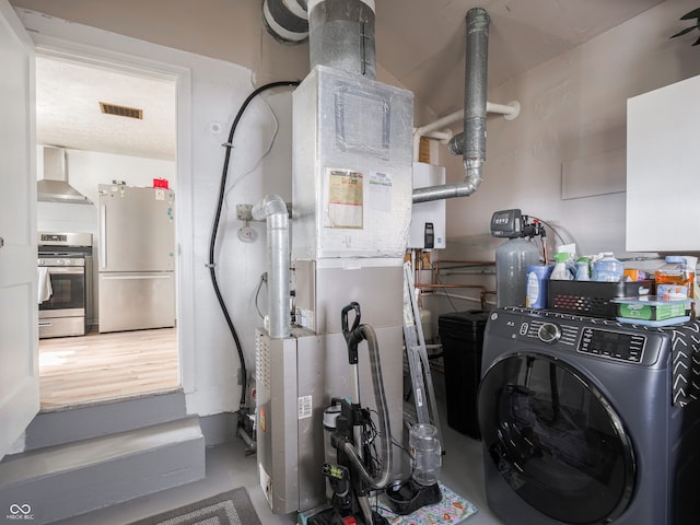 clothes washing area featuring laundry area, visible vents, a textured ceiling, and washer / dryer