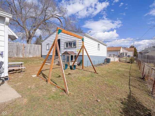 exterior space with a playground and a fenced backyard