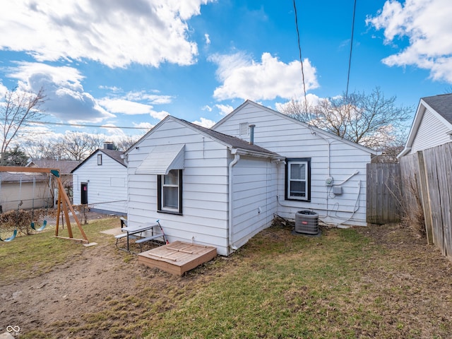 back of house with a lawn, cooling unit, and fence