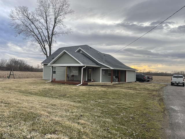 view of front of house featuring a shingled roof and a front lawn