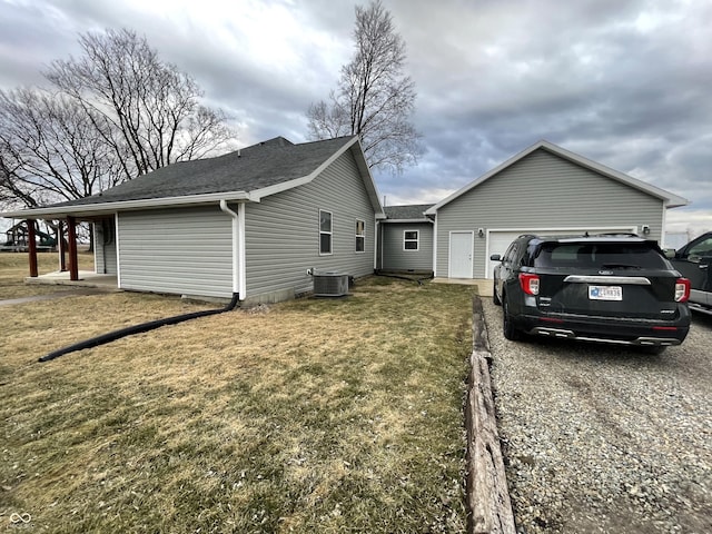 view of property exterior featuring a garage, driveway, a shingled roof, a yard, and central AC