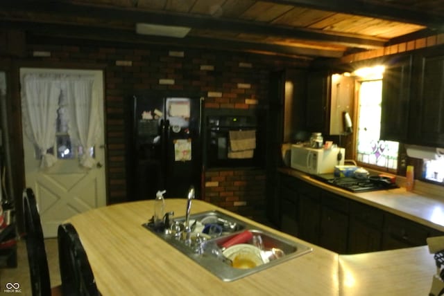 kitchen featuring black appliances, beamed ceiling, brick wall, and wood ceiling