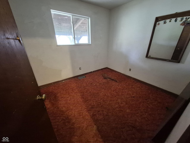 spare room with visible vents, baseboards, and carpet flooring