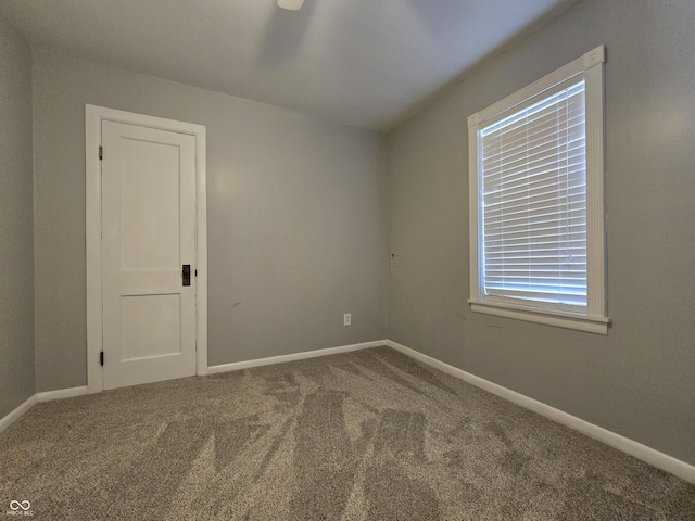 carpeted spare room with baseboards