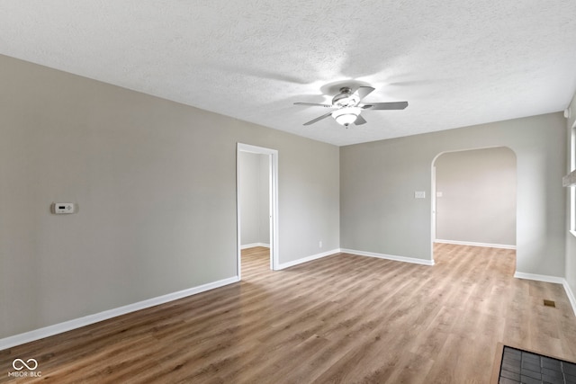 305 Bixler Rd, Indianapolis, IN 46227 - empty room with baseboards, arched walkways, a ceiling fan, wood finished floors, and a textured ceiling