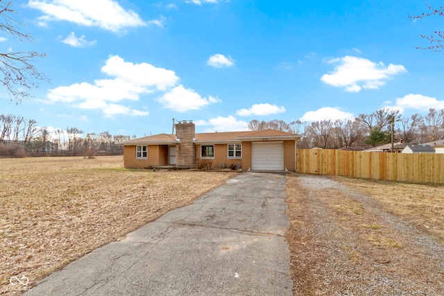 single story home with a garage, aphalt driveway, a chimney, and fence