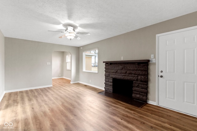 305 Bixler Rd, Indianapolis, IN 46227 - unfurnished living room with arched walkways, ceiling fan, a fireplace, and wood finished floors