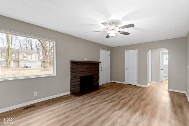305 Bixler Rd, Indianapolis, IN 46227 - unfurnished living room with arched walkways, a fireplace, wood finished floors, and baseboards