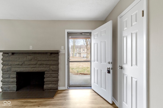 305 Bixler Rd, Indianapolis, IN 46227 - doorway to outside featuring a textured ceiling, a fireplace, wood finished floors, and baseboards