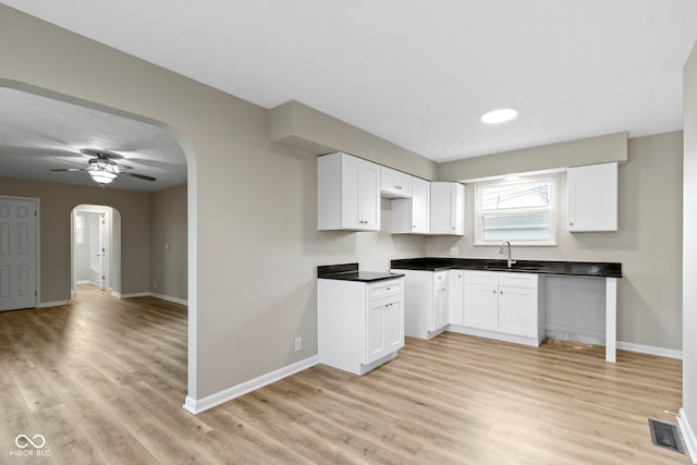 305 Bixler Rd, Indianapolis, IN 46227 - kitchen featuring baseboards, visible vents, arched walkways, light wood-style flooring, and a sink