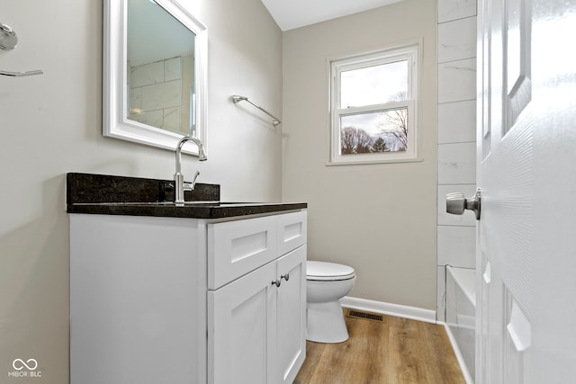 305 Bixler Rd, Indianapolis, IN 46227 - full bathroom with baseboards, visible vents, toilet, wood finished floors, and vanity