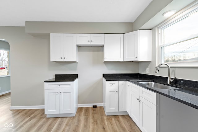 305 Bixler Rd, Indianapolis, IN 46227 - kitchen with light wood-type flooring, dark stone countertops, a sink, and white cabinets