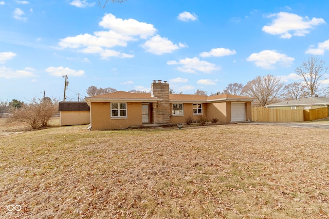 single story home with a garage, a chimney, a front yard, and fence