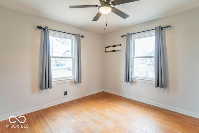 empty room featuring a healthy amount of sunlight, light wood-style flooring, and baseboards