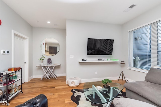 living room with recessed lighting, wood finished floors, visible vents, and baseboards