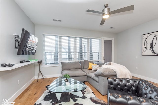 living area featuring light wood-style floors, baseboards, and visible vents