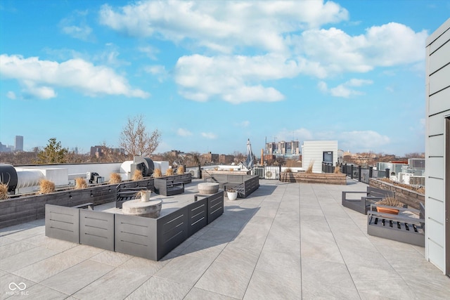 view of patio with a view of city, an outdoor kitchen, and an outdoor hangout area