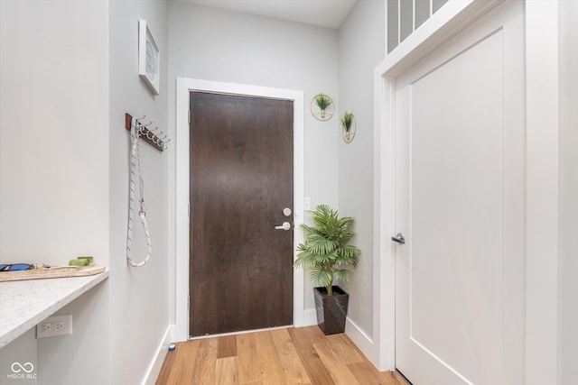 foyer entrance with light wood-type flooring and baseboards