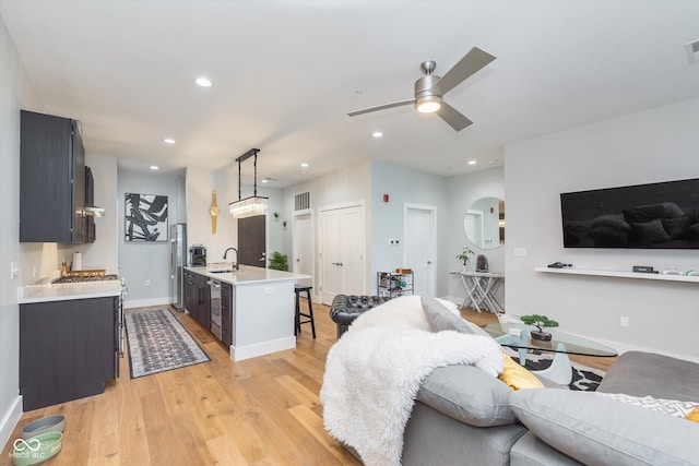 living area with light wood finished floors, visible vents, arched walkways, ceiling fan, and recessed lighting