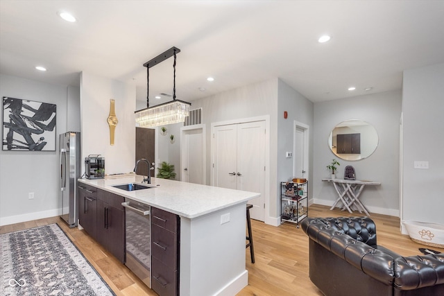 kitchen with light wood-style floors, freestanding refrigerator, a sink, and recessed lighting