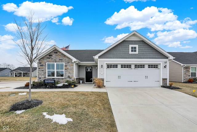 craftsman-style house with driveway, stone siding, an attached garage, and a front lawn