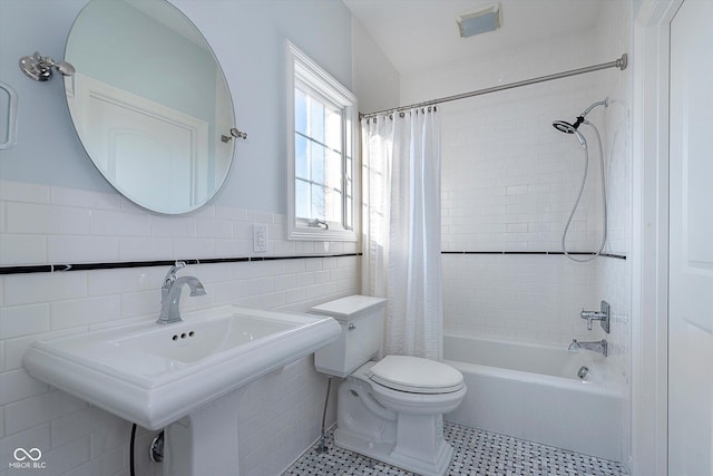 full bath with a wainscoted wall, tile walls, shower / bath combination with curtain, visible vents, and toilet