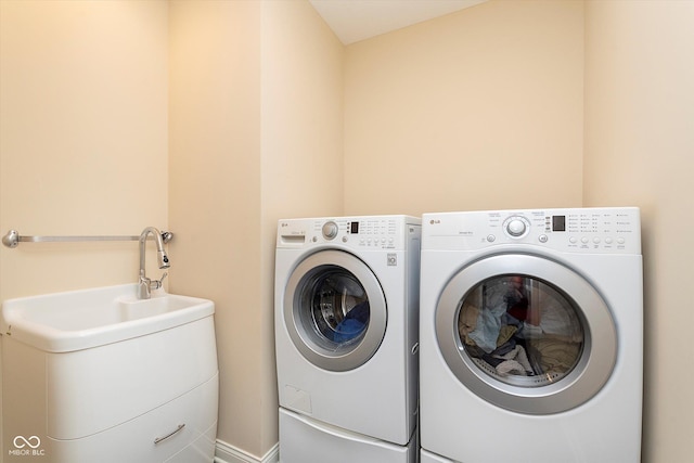 washroom featuring laundry area, a sink, and washing machine and clothes dryer