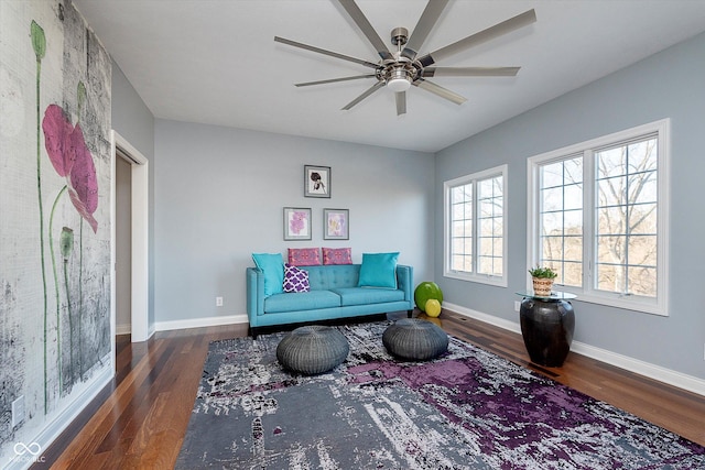 sitting room with wood finished floors, a ceiling fan, and baseboards