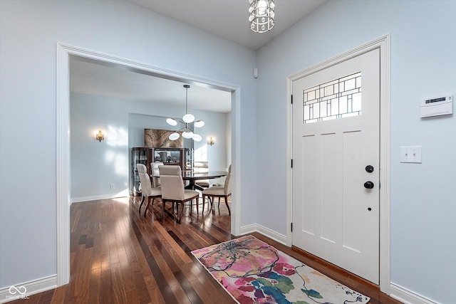 entrance foyer with baseboards, hardwood / wood-style floors, and a notable chandelier