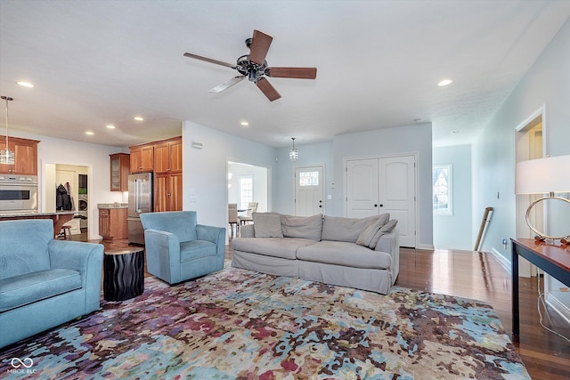 living room featuring baseboards, dark wood-type flooring, plenty of natural light, and recessed lighting