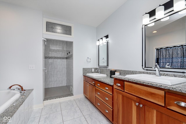 bathroom featuring marble finish floor, tiled shower, a sink, and double vanity